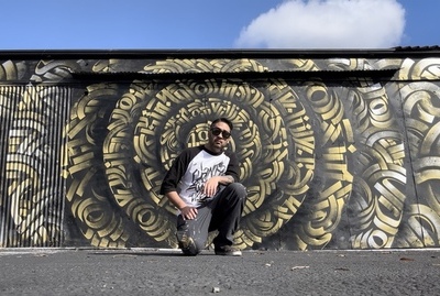Zak Perez in front of his mandala mural in downtown Santa Ana