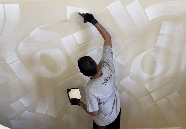 Zak Perez painting an accent wall mural in an art collector's private residence