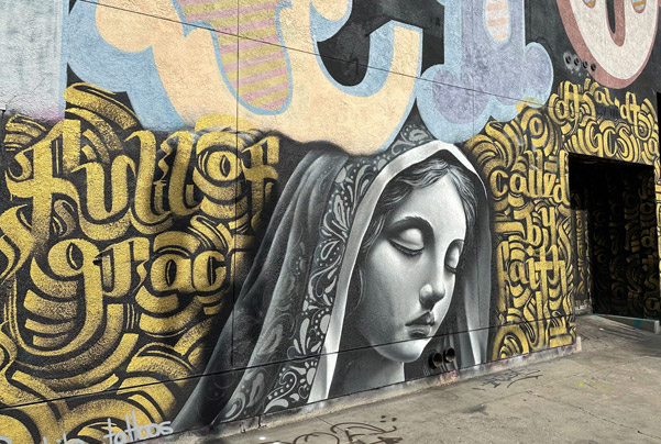 Mural in DTSA with gold lettering and a portrait of Mary - Zak Perez collab