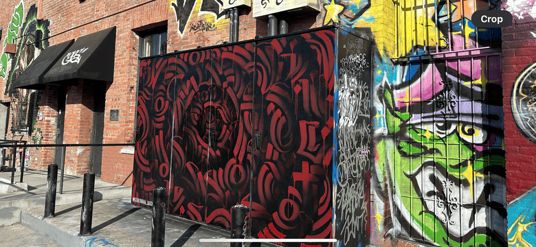 Red mandala graffiti mural surrounded by other graffiti art