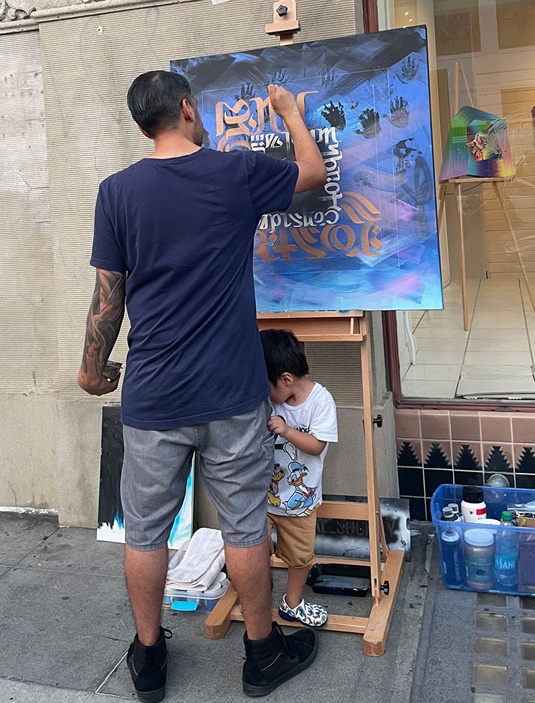Zak Perez painting a canvas live during the DTSA Art walk