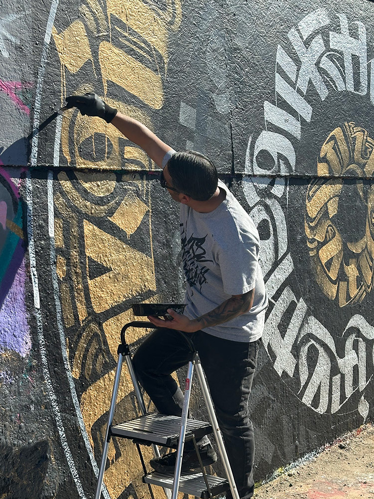 A close up of Zak Perez painting a live mural at The Graff Lab in LA